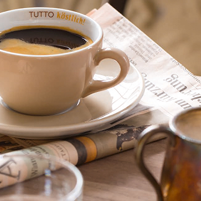 Eine Tasse Verlängerter auf einer Zeitung