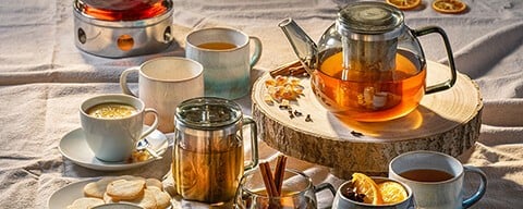 Mehrere Teekannen, Teegläser, Teetassen, Kekse, Zimtstangen und mehr