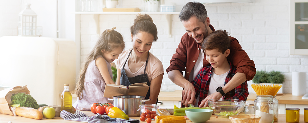 Glückliche Familie, die gemeinsam mit den Kindern in der Küche kocht. 