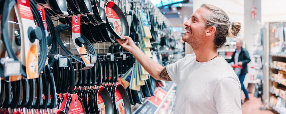 Ein Mann beim Aussuchen von Pfannen in einem INTERSPAR-Hypermarkt