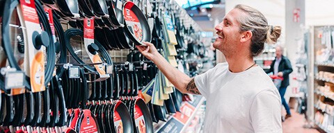 Ein Mann beim Aussuchen von Pfannen in einem INTERSPAR-Hypermarkt