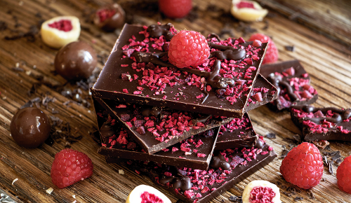 Mehrere handgemachte Tafeln Schokolade mit Himbeeren verziert
