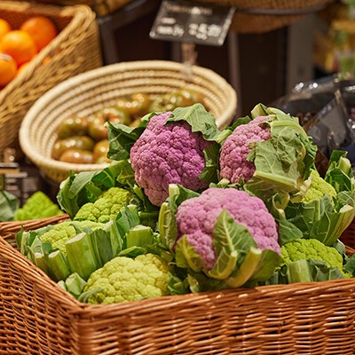 Mehrere bunte Blumenkohl in einem Aufsteller in einem INTERSPAR-Hypermarkt