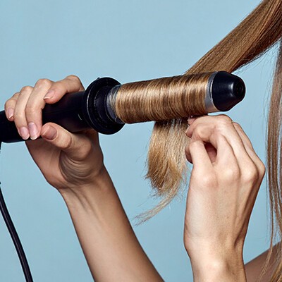 Locken drehen mit einem Lockenstab.