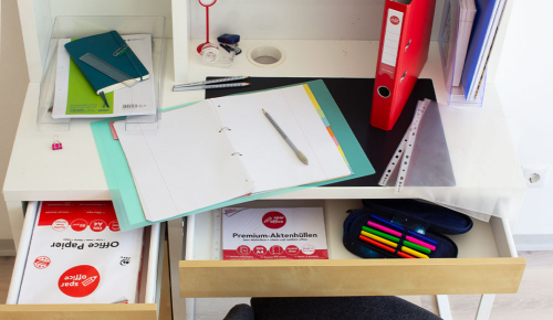 Schulhefte, Stifte und weitere verschiedenes Büromaterial auf einem Kinderschreibtisch