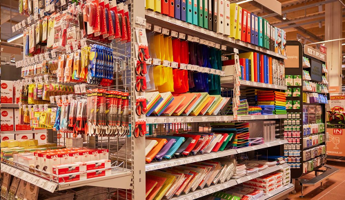 Viele verschiedenen bunte Ordner in einem INTERSPAR-Regal