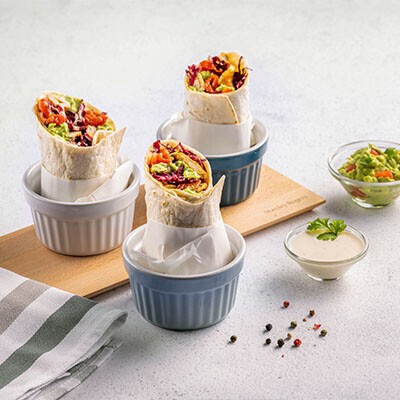 Wraps in Butterbrotpapier in kleinen Schälchen aufgestellt