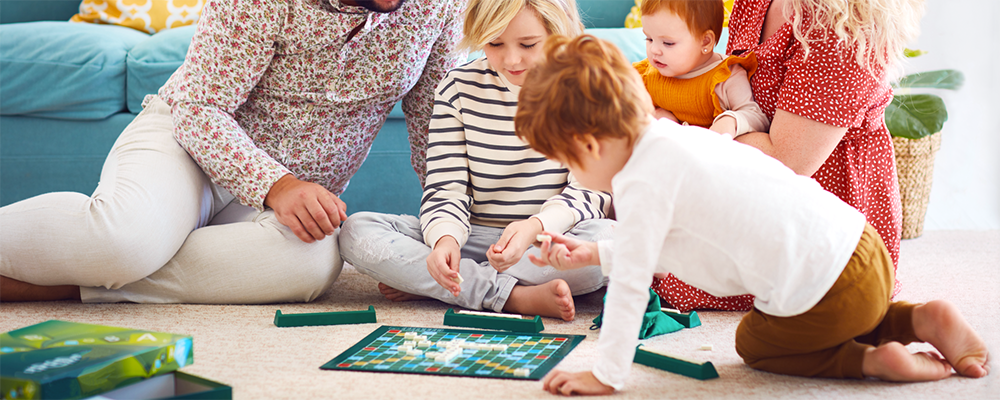 Eine Familie beim Spielen eines Brettspieles am Boden