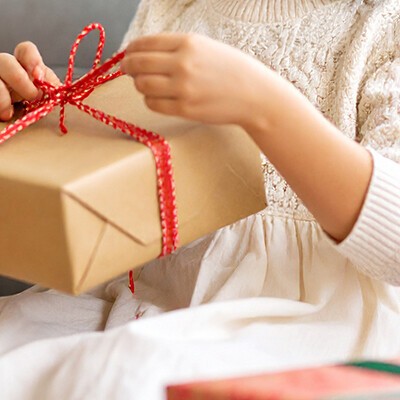 Ein Kind beim Auspacken von Geschenken auf einem Sofa