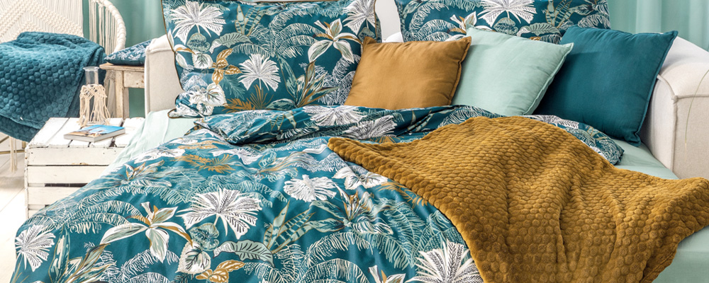 Eine hellblau-weiß gemusterte Bettwäsche auf einem Bett