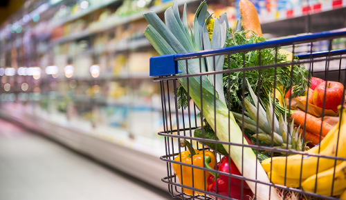Einkaufswagen voller Gemüse- und Obst-Einkäufe in einem Supermarkt