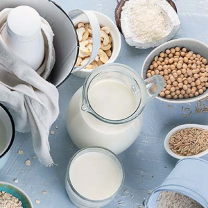 Vegane Backalternativen wir Hafermilch und Samen auf einem Tisch