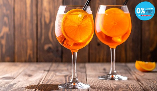 Zwei Gläser gefüllt mit alkoholfreiem Aperol, Orangenscheiben und einem Strohhalm 