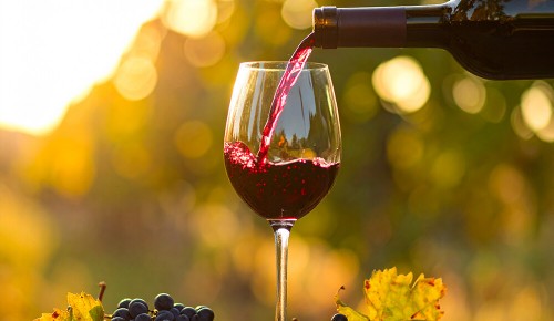 Rotwein wird gerade in ein Weinglas eingeleert