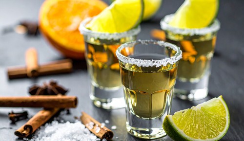 Drei gefüllte Tequila-Shotgläser mit Salz-Rand und Limettenscheiben