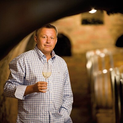 Ein Mitarbeiter vom Weingut Dürnberg mit einem Weinglas im Weinkeller