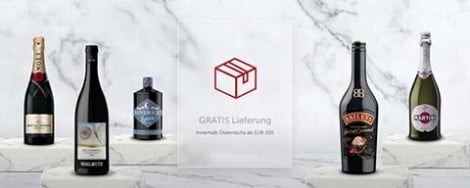 Mehrere Weinflaschen und eine Box mit der Aufschrift "Gratis Lieferung innerhalb Österreichs ab EUR 100"
