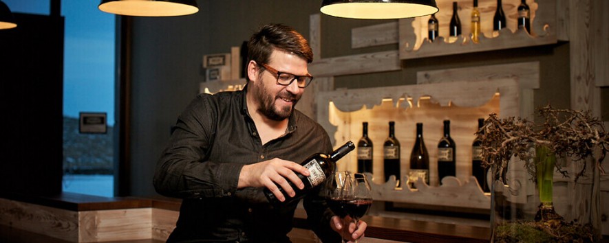 Hannes Reeh beim Einschenken von Rotwein in ein Weinglas