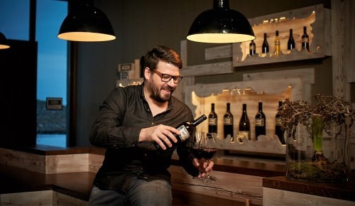 Hannes Reeh beim Einschenken von Rotwein in ein Weinglas