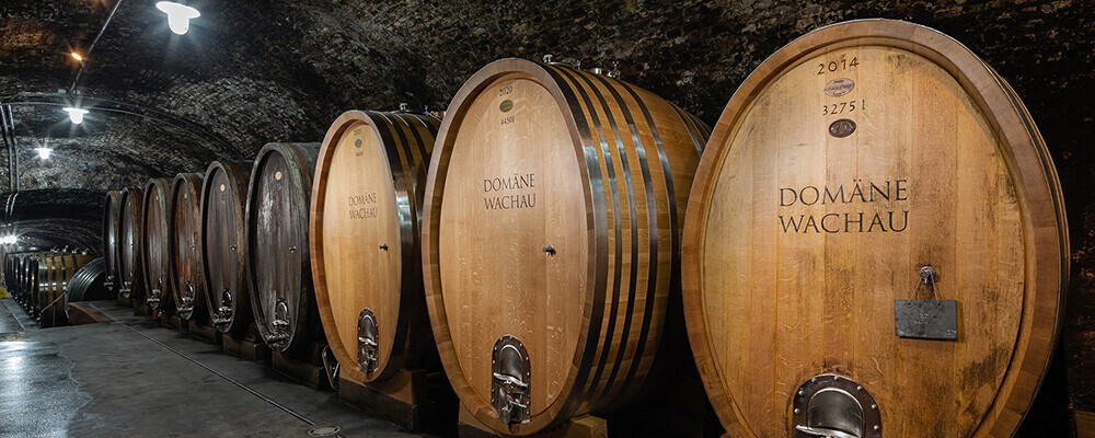 Mehrere großen Weinfässer vom Weingut Domäne Wachau in einem Keller
