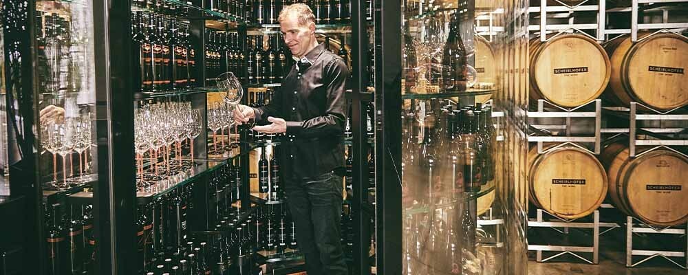 Winzer vom Weingut Scheiblhofer in einem Raum voller Weine