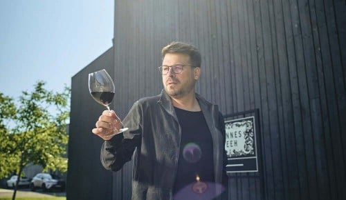 Winzer Hannes Reeh mit einem Weinglas in der Hand
