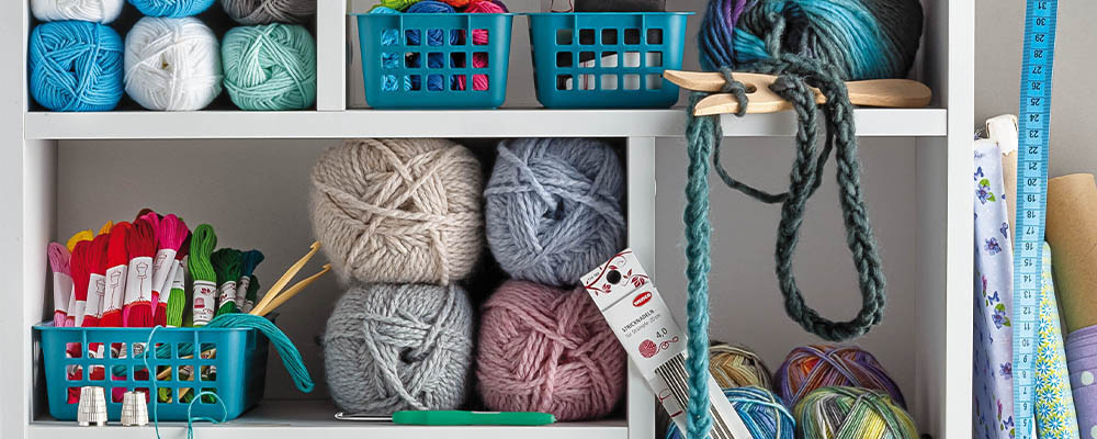 Viel verschiedenes Näh- und Strickzubehör in einem Regal