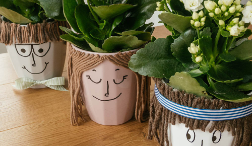 Ein selbstgebastelter Blumentopf mit Gesicht und Haaren aus Wolle