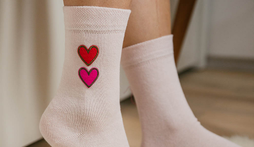 Weiße Socken mit kleinen roten Herzen auf der Seite