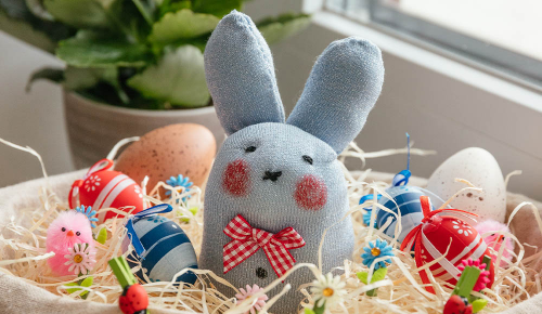 Ein selbstgebastelter Osterhase aus Socken in einem Nest