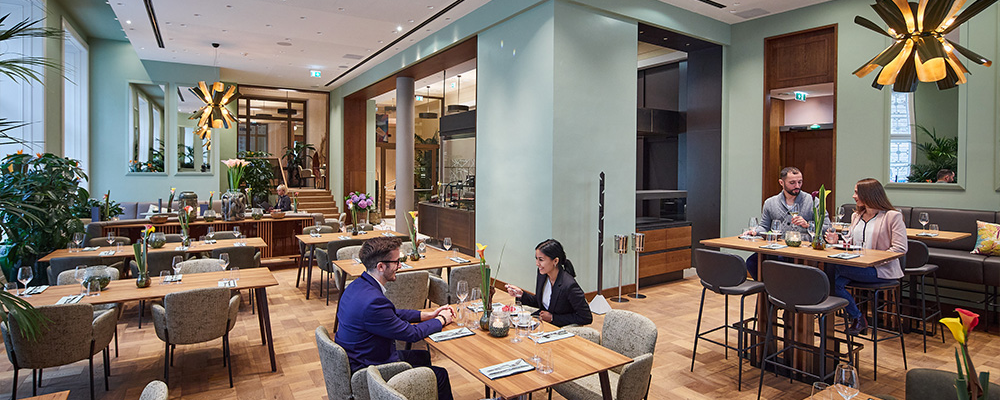 Personen sitzen im Restaurant Das Mezzanin und Essen