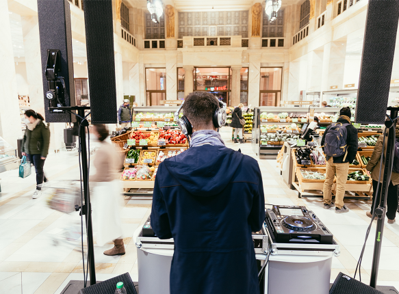 DJ an einem Mischpult mit dem Rücken zur Kamera
