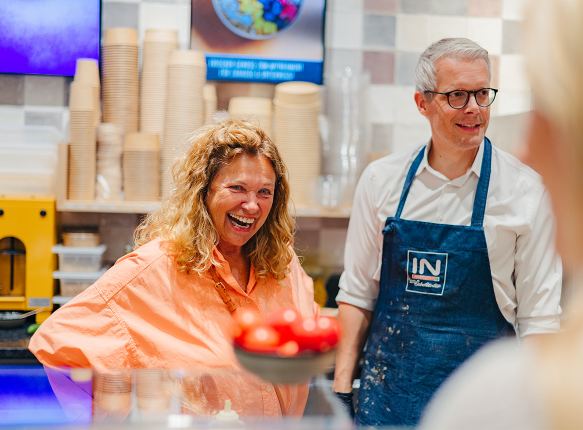 Ein Mann und eine Frau an einem Buffet beim Lachen