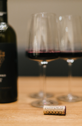 Gläser mit Rotwein und ein Weinkorken auf einem Tisch