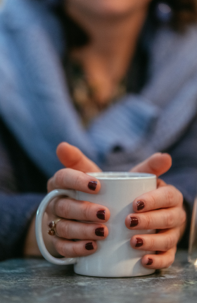 Eine Person hält eine Tasse in den Händen