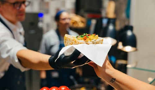 Eine Person bekommt einen Döner gereicht