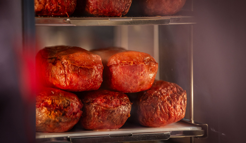 Mehrere ganze Leberkäse in einer Wärmhaltevitrine