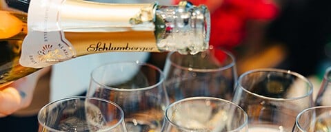 Sekt der aus einer Flasche in Sektgläser gegossen wird