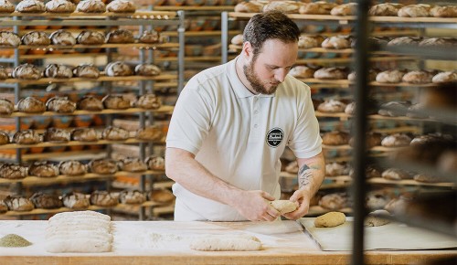 Ein Mitarbeiter der INTERSPAR Bäckerei beim Formen von Semmeln