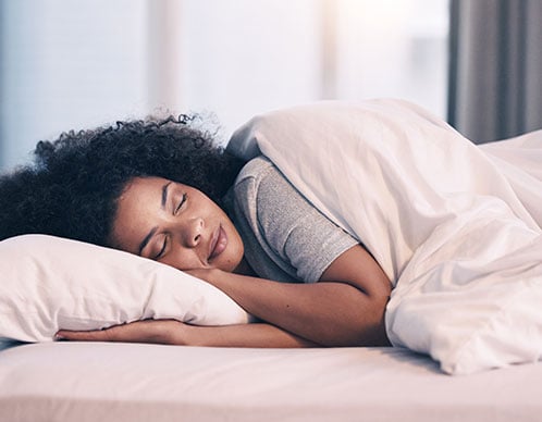 Frau schläft in einem Bett